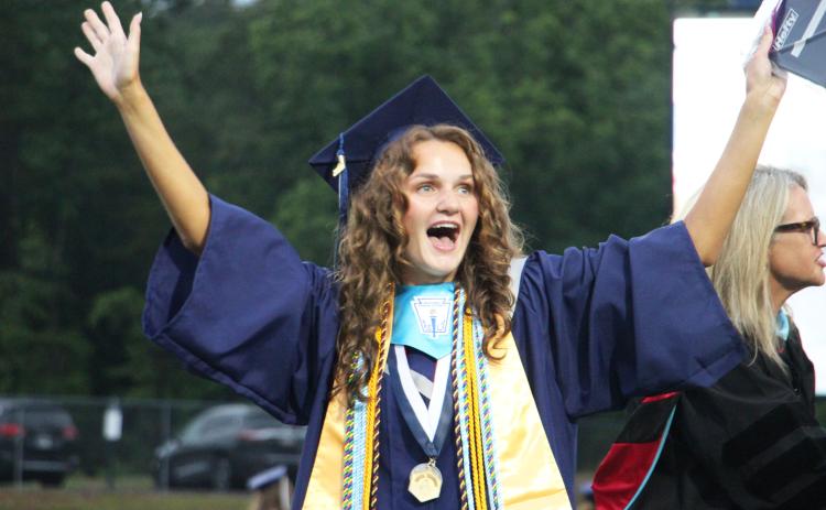 Caroline Tatum throws her hands in the air in celebration after receiving her diploma during the 2026 White County High School graduation ceremony. CARLY HENDERSON/WCN