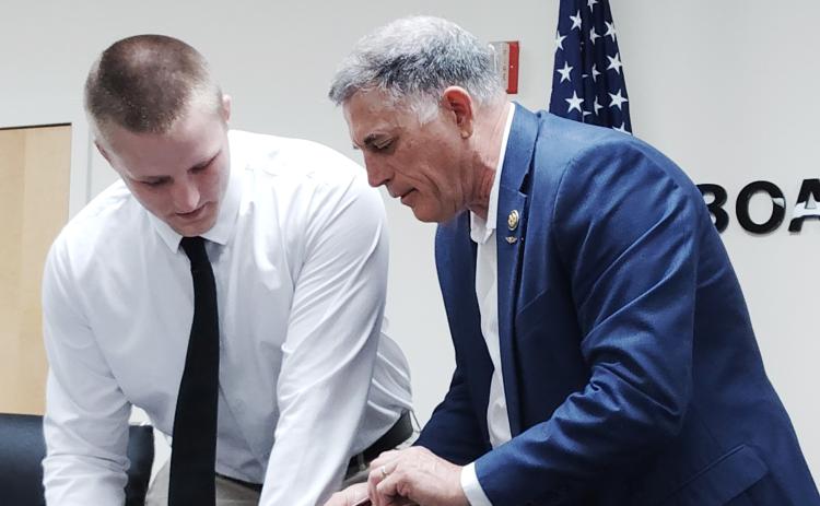White County High School graduate Bryson Howe, left, prepares to sign his commitment pledge during a signing ceremony on June 18. Howe received a congressional appointment to the U.S. Naval Academy from Congressman Andrew Clyde, right.