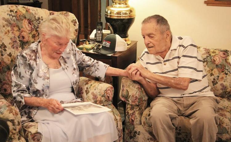 Monique Souris becomes emotional while looking at a wartime-era photograph from Lorient as Andy Negra holds her hand during their meeting. PHOTOS BY CARLY HENDERSON/WCN