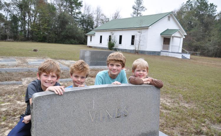 In 2017 four of our eight grandchildren visited the graves of their ancestors at Pilgrims Home Free Will Baptist Church on Hwy. 91 in Baker County, Georgia. The Wilsons are, from left, Hayes, Henry, Wyatt and Smith. They are posing by the granite tombstone of my mother’s parents, Howell and Essie (Nanny) Vines. (Photo by Dink NeSmith)