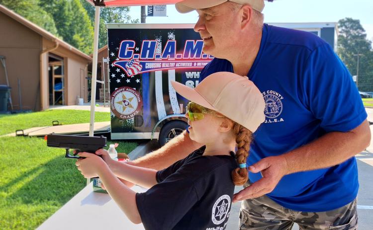 Sgt. Daren Welborn shows Graylee Schrader how to properly handle and discharge a firearm, or pellet gun in this case, at the 2026 Junior Law Enforcement Academy. PHOTOS BY ERIN ETRIS/WCN