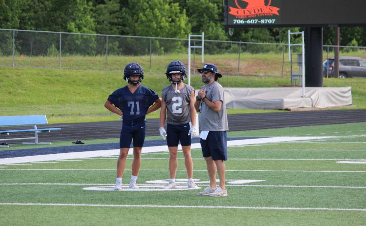 WCHS defensive coordinator Zac Grace, right, talks with Zach Godfrey, middle, and Savion Anderson during a recent practice.