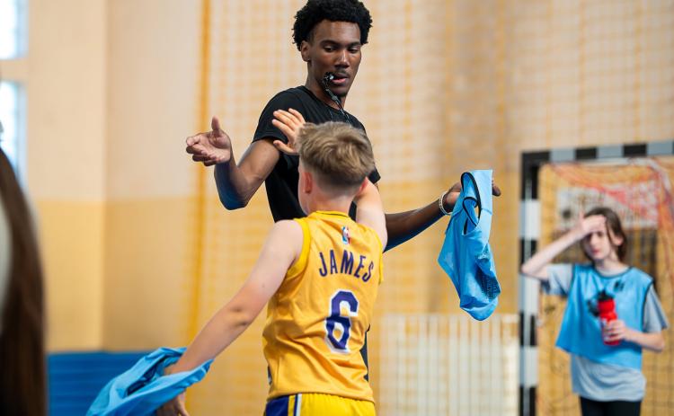 TMU basketball player Preston Tuggle high-fives a camper during a camp that was part of the mission trip to Poland this summer. RADIO STREFA FM/SPECIAL