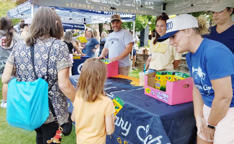 Mt. Yonah Elementary School Principal Juliana Dean, far right, greets a young student at the Back-to-School Bash last Saturday. Assistant principal Ryan London is at far left. At center is first grade teacher Caroline Duffey and behind Dean is instructional coach Jade Bates. PHOTOS BY DENISE ETHERIDGE/WCN