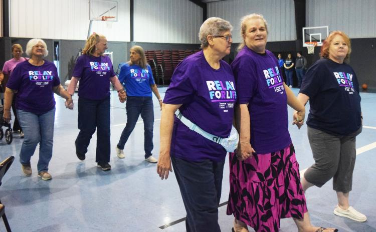 Denise Miller, front row center, walks the survivor’s lap with fellow cancer survivors at last year’s Relay for Life. FILE PHOTO