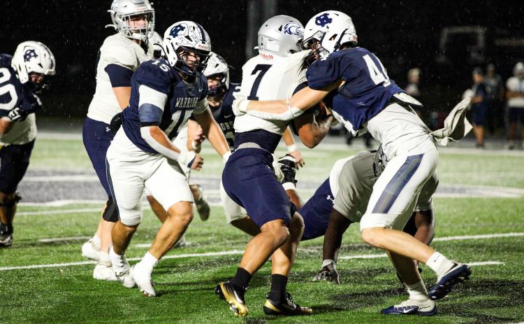 White County's Sam Harkins, right, wraps up East Jackson running back Tristan Sloane during the first of the Warriors' win last Friday night in Cleveland. STACI SULHOFF/SPECIAL