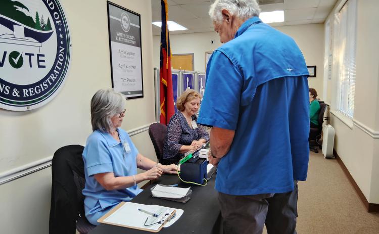 Poll workers Lisa Reed, left, and Tracy Stout, right, assist a White County voter who came to vote early in the midterm election last week. DENISE ETHERIGE/WCN